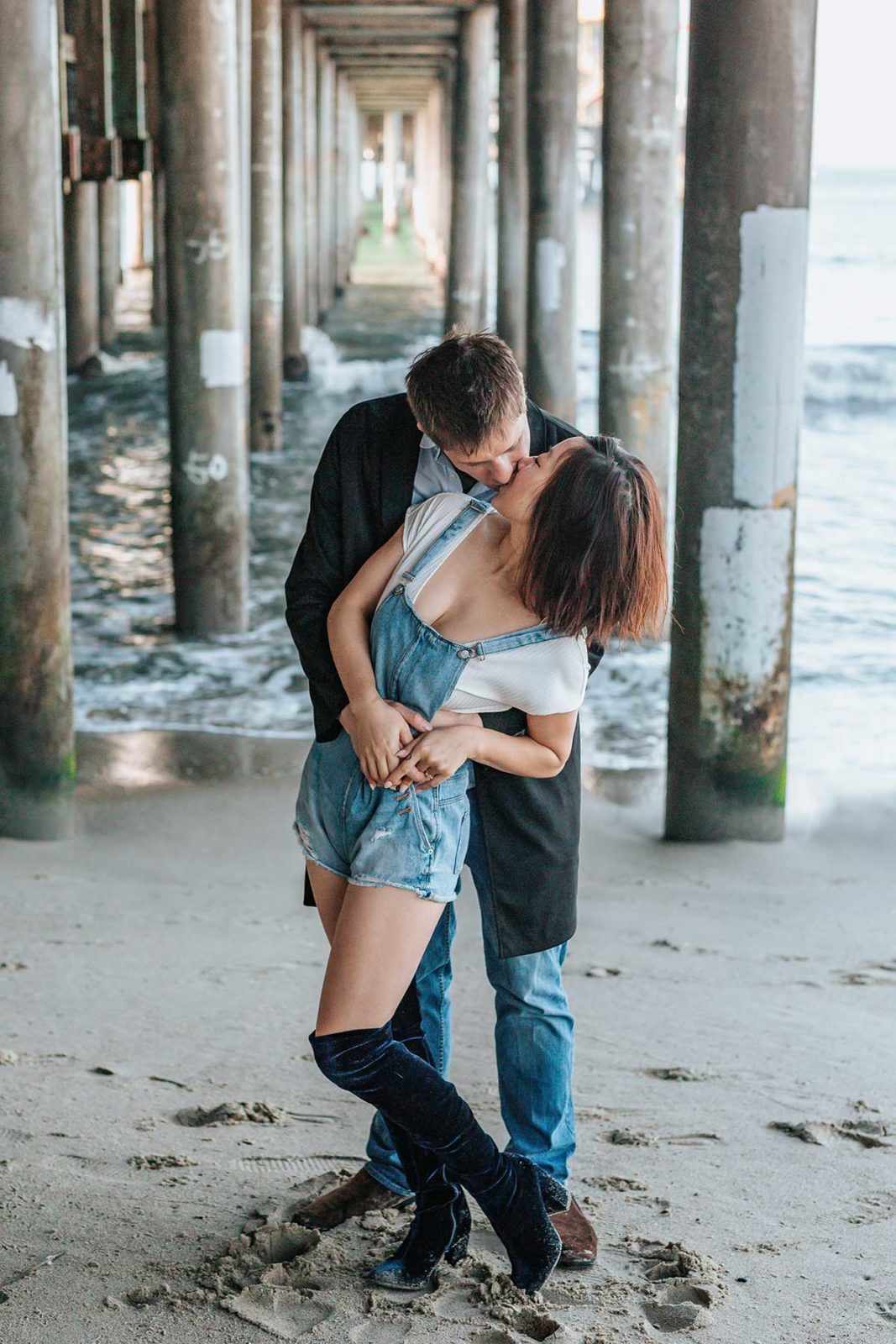 Парень целует девушку под мостом