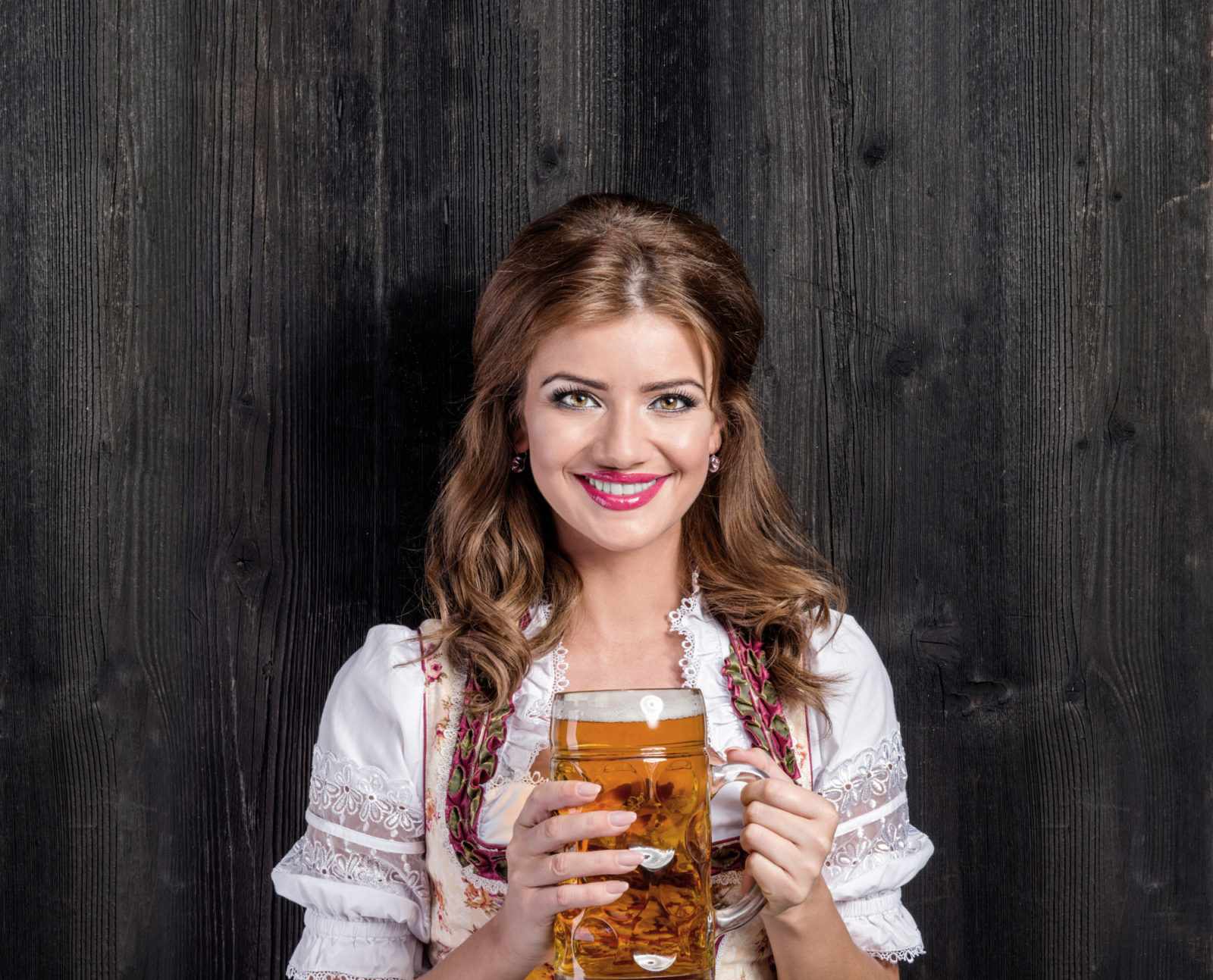 Немецкая женщина в традиционном баварском платье держит пиво
