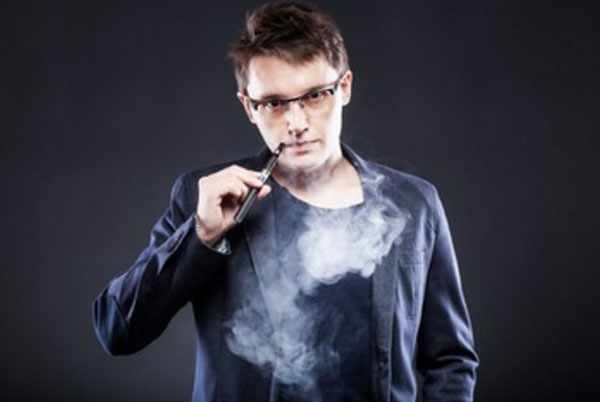Мужчина курит электронную сигарету