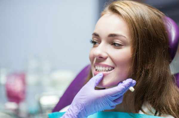 Девушка с белоснежной улыбкой на кресле у стоматолога