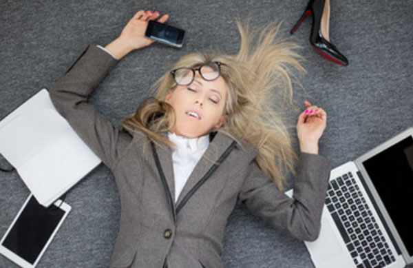 Женщина лежит на полу без сознания, рядом ноутбук, телефон, бумаги
