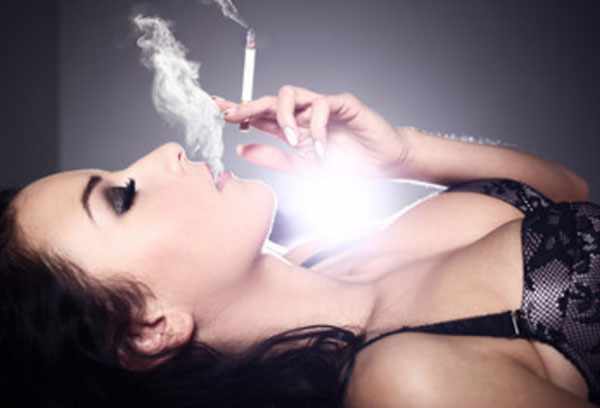 Привлекательная женщина лежит и курит