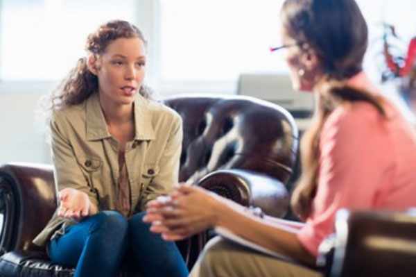 Психотерапевт общается с женщиной